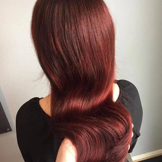 A woman with a beautiful magenta hairstyle