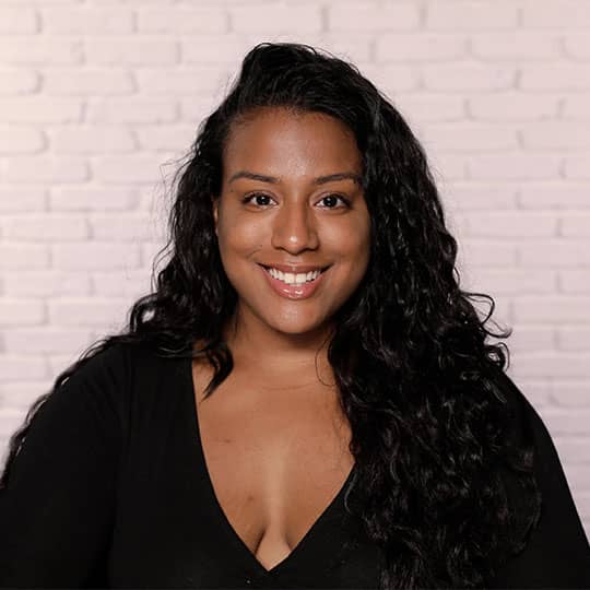 woman with long hair smiling at camera showing hairline