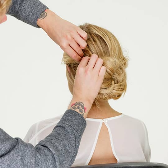 man styling woman's new years eve bun