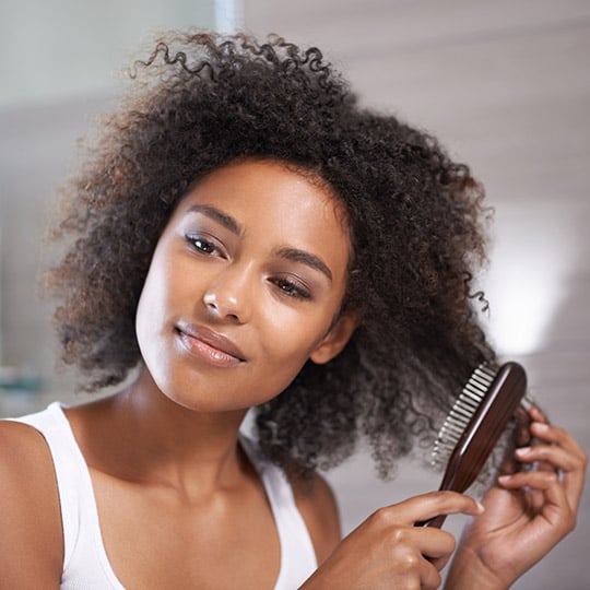 woman brushing her curly hair