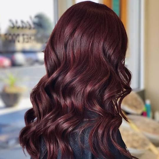 A woman with a beautiful magenta hairstyle