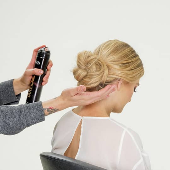 man spraying woman's new years eve hair
