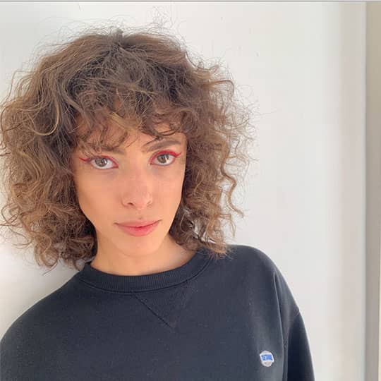 woman with curly hair at paris fashion week